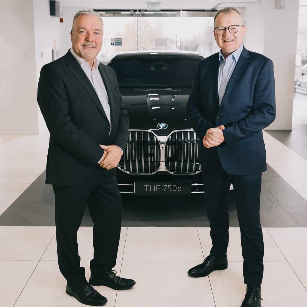 A photo of Jim Power who Joins BMW as an Independent Non-executive Director with Brian Merrigan, CEO of BMW Financial Services Ireland, in the back is a black BMW