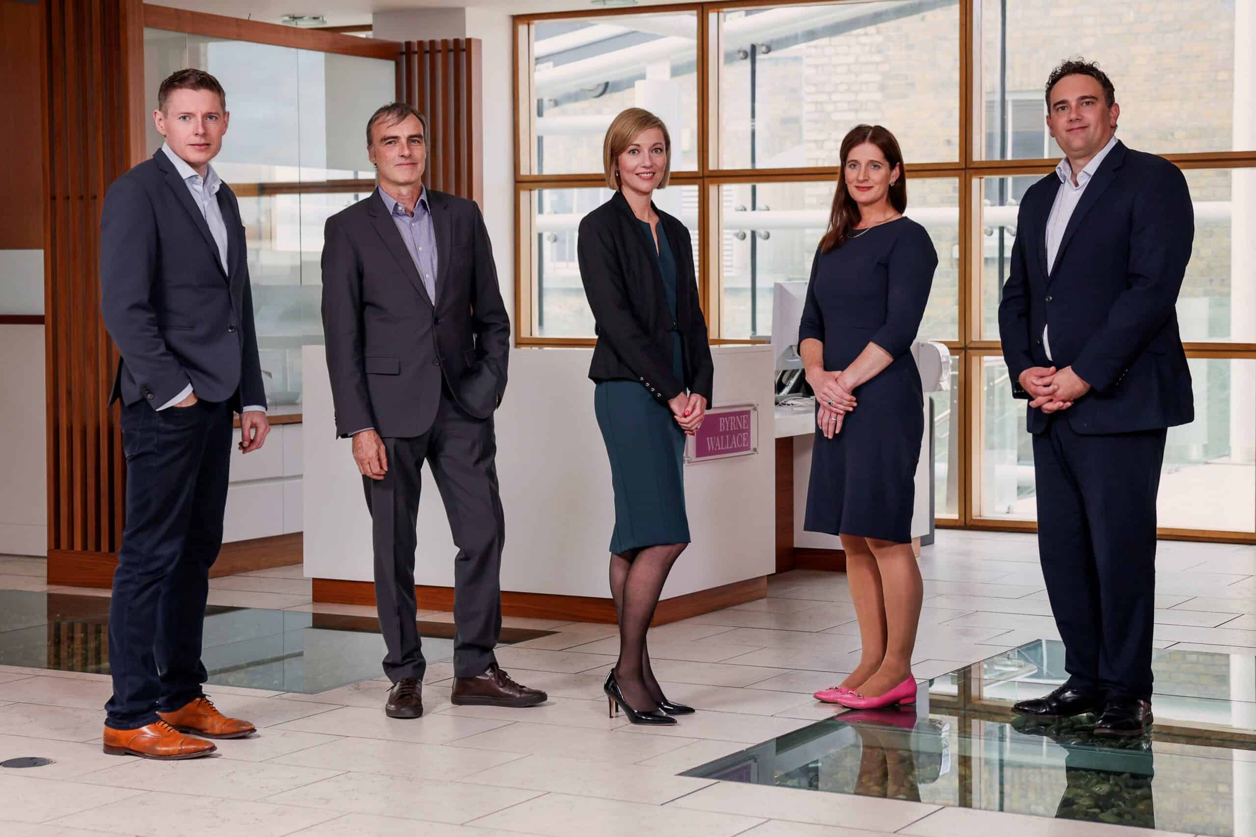 Photo of Nadia de Wet with three colleagues, new Tax Director and Head of Compliance Services at ByrneWallace, with the company logo in the background.
