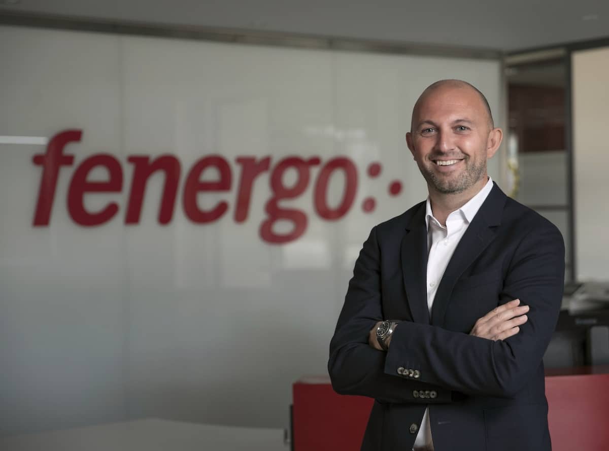 A photo of Mike Murphy, CEOf at Fenergo, standing with his hands crossed. The Fenergo logo is visible on the back wall.