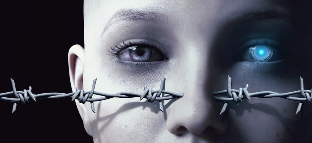 Close-up of a humanoid face with one natural eye and one robotic eye, mouth covered by barbed wire.